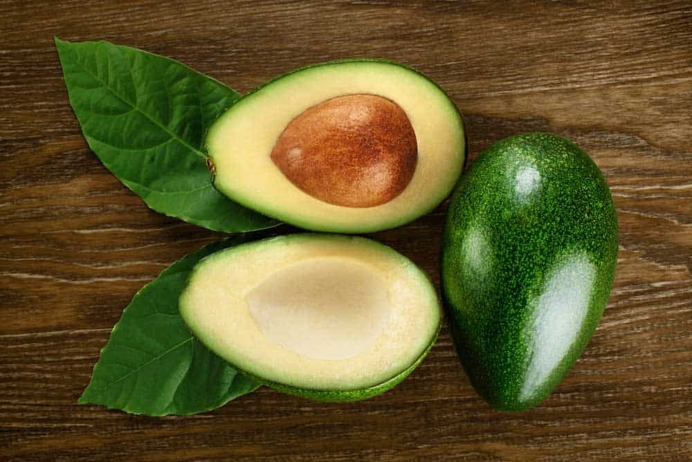 Avocado tree produces oval or egg-shaped fruit that has fleshy structure and large seed in the middle.